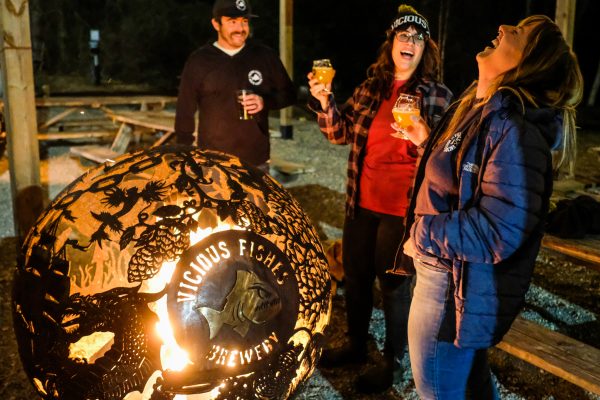 a group of people enjoying a beer and bonfire