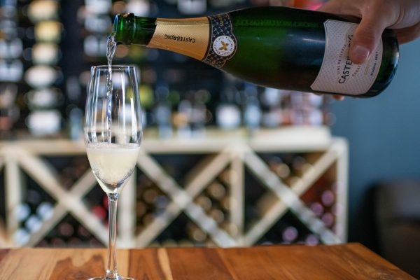 a person pouring champagne into a glass