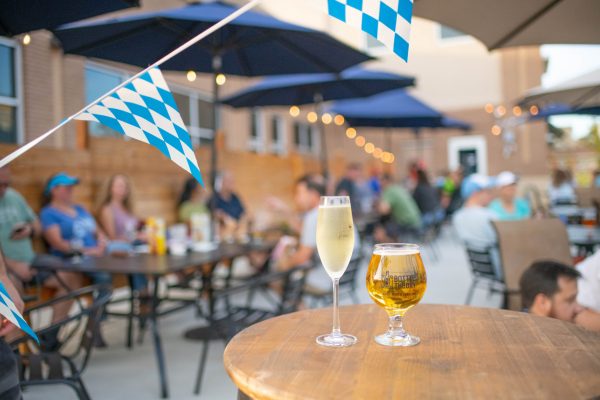 a glass of wine and beer outside on a table