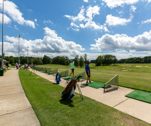 people golfing at a driving range